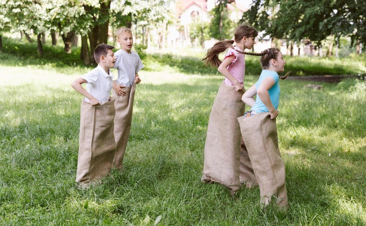 Side view children playing in burlap bags
