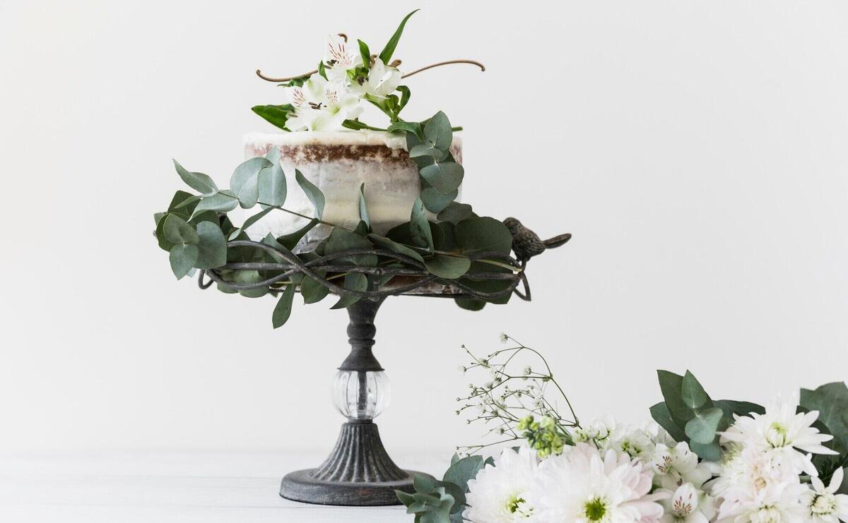 Wedding cake on cakestand decorated with white flower bouquet