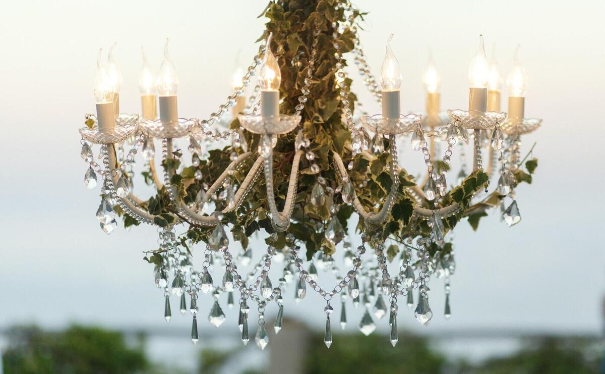 Crystals hang from the chandelier decorated with greenery