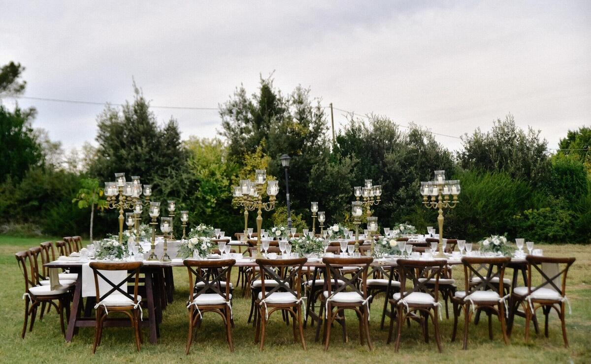 Decorated wedding celebration table with guests seats outdoors in the gardens
