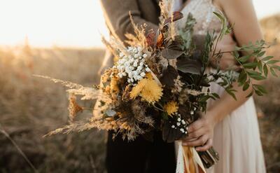 Beautiful bouquet of wild flowers in the hands of the bride