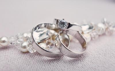 Classy silver wedding rings made of white gold lie on the crystal bracelet