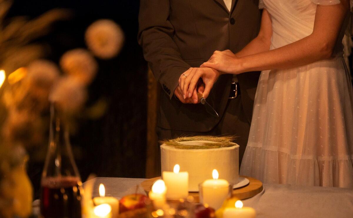 Side view bride and groom cutting cake