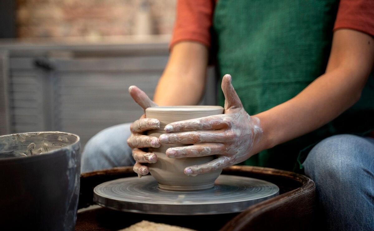 Hands doing pottery side view