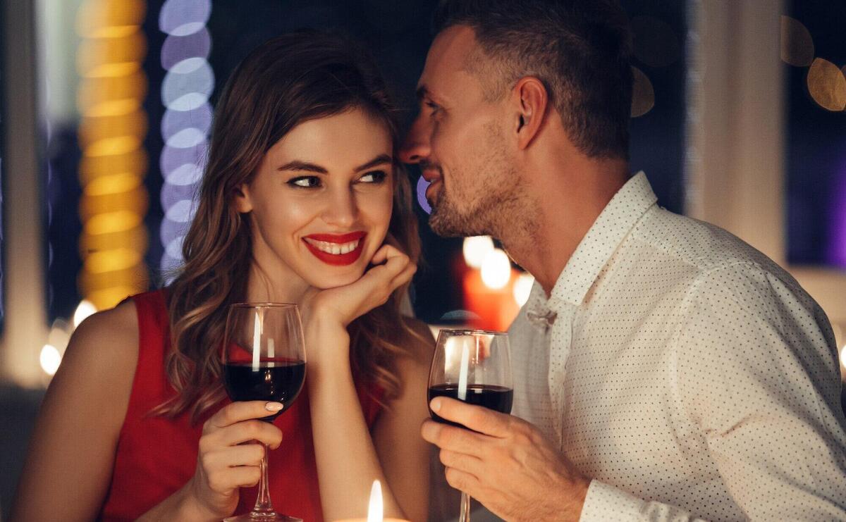 Young handsome man whisper to his woman while have romantic dinner