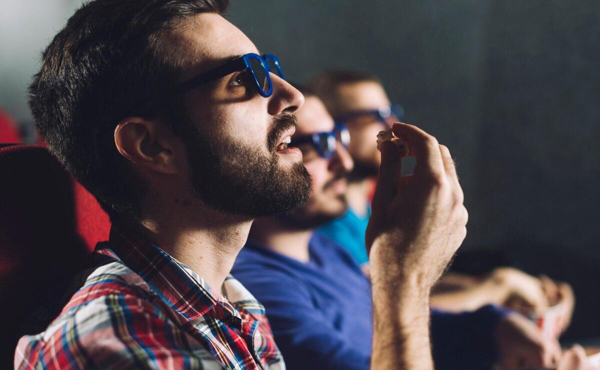 Man eating popcorn during cinema show