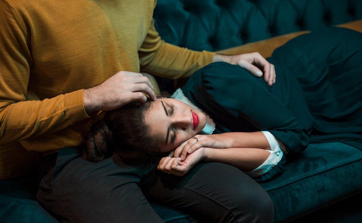 Man embracing woman lying on legs