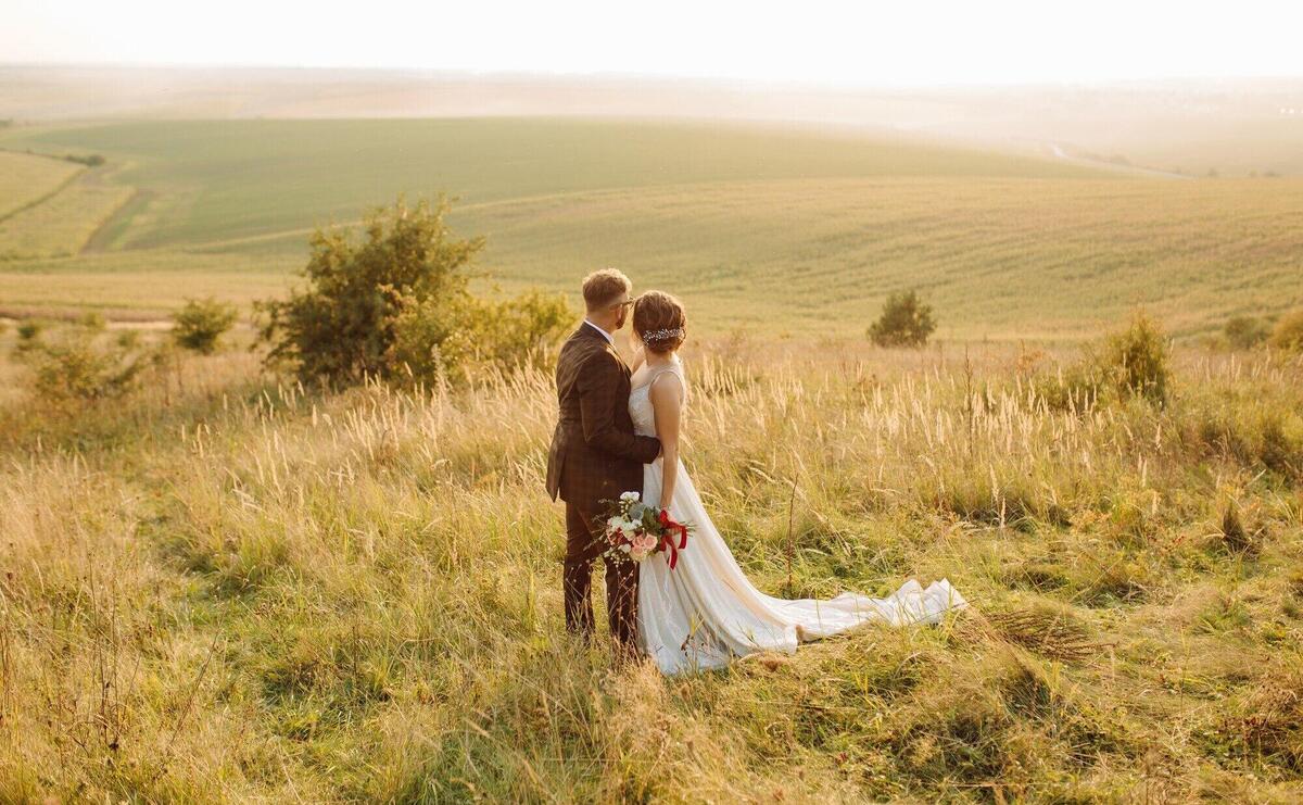 Loving couple wedding newlyweds outside at sunset in beautiful summer day