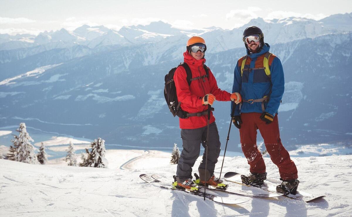 Two skiers standing together on snow covered mountain