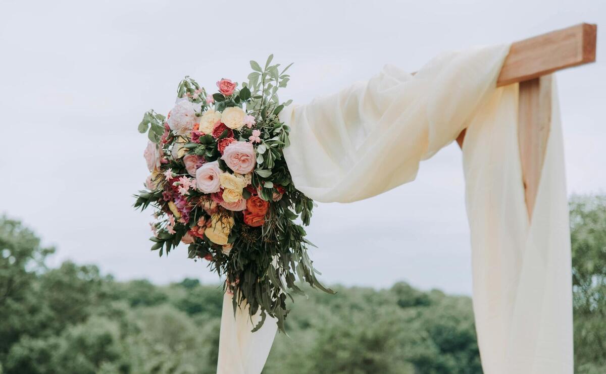 bouquet of assorted-color flowers hanged on brown plank with white textile