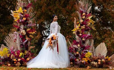 Smiley bride posing with flowers side view